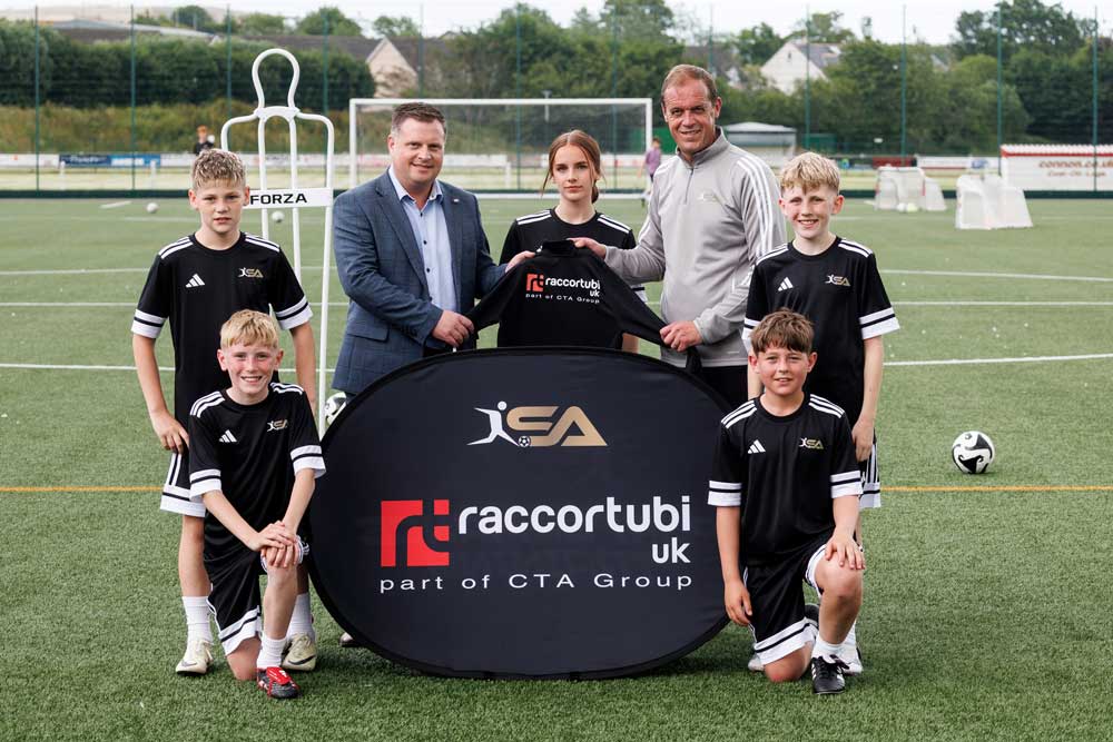 Andy Troup posing with Scott Anderson, a group of young football players and the sponsored SA Performance Training football kit.
