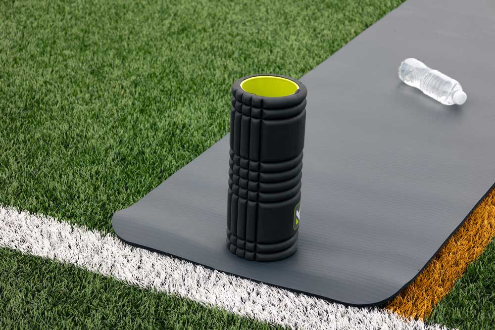 Fitness roller standing upright on a yoga mat.